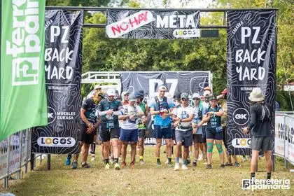 Grupo de corredores esperando bajo el arco 'No hay meta' antes de la salida del PZ Backyard Ultra