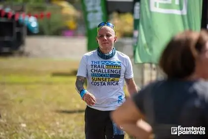 Corredor con camiseta de Trail Challenge Sunset Costa Rica celebra con el puño en alto