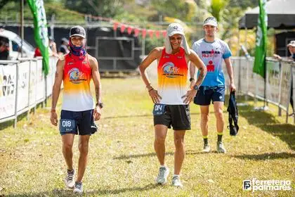 Dos corredores con camisetas degradadas en rojo y naranja caminando juntos tras terminar